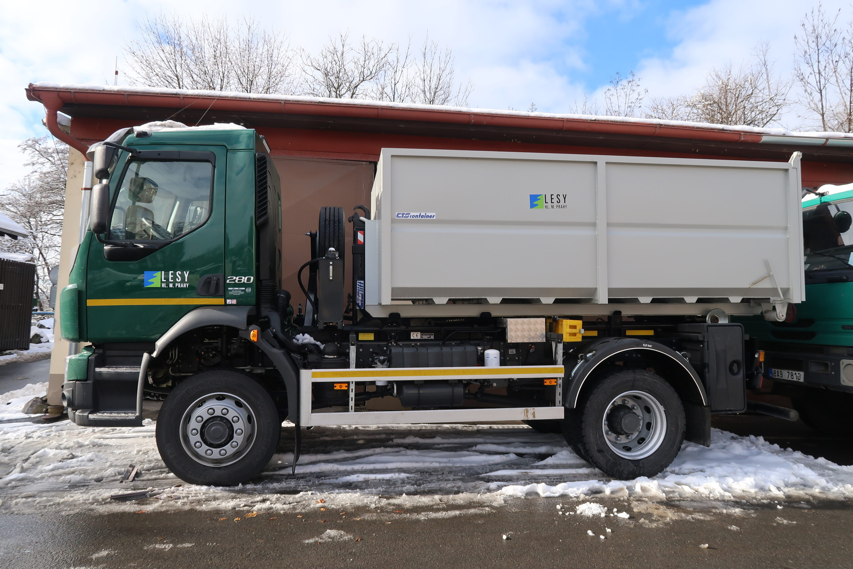 Řidič nákladního vozidla s hákovým nosičem kontejnerů s hydraulickou rukou